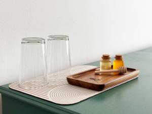 two glass vases sitting on a cutting board with a wooden tray at Dabfly Guesthouse & Outdoor Adventures in Ražanj