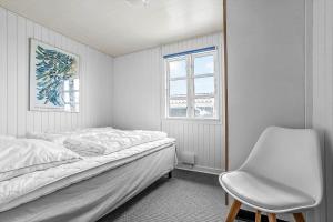 a white bedroom with a bed and a chair at SJ243-Haderslev-Vikaerparken-79 in Haderslev