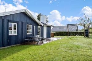 a blue house with a picnic table in the yard at SJ243-Haderslev-Vikaerparken-79 in Haderslev