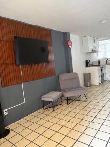ein Zimmer mit einem Stuhl und einem Flachbildfernseher in der Unterkunft Casa Torremolinos en Coto Privado in Zapopan + 8 Fotos