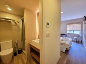 a bathroom with a toilet and a bed in a room at AL Ponto Norte in Melgaço +141 photos