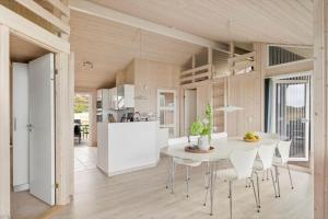 a kitchen and dining room with a white table and chairs at LN602-Hjorring-Harerenden-71 in Hjørring
