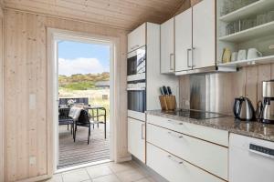 a kitchen with white cabinets and a patio with a table at LN602-Hjorring-Harerenden-71 in Hjørring +10 photos