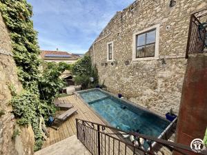 a building with a swimming pool next to a building at Le gîte du clos in Roquefort-des-Corbières