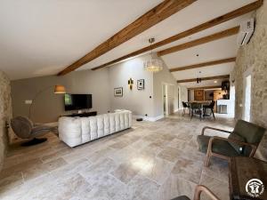 a living room with a white couch and a table at Le gîte du clos in Roquefort-des-Corbières