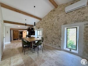 a kitchen and dining room with a table and chairs at Le gîte du clos in Roquefort-des-Corbières
