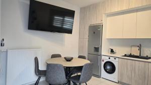 a kitchen with a table with chairs and a tv on the wall at Paralia Sea View Suites in Paralia Katerinis +20 photos