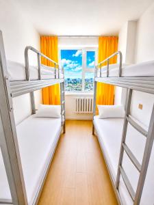 two bunk beds in a room with a window at Yura Hostel in Darhan
