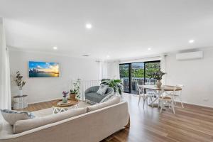 a living room with a couch and a table at North Avoca Coastal Escape in North Avoca