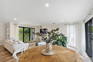 a living room with a vase on a wooden table at North Avoca Coastal Escape in North Avoca +23 photos