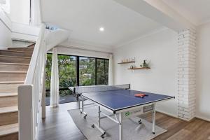 a ping pong table in a room with a staircase at North Avoca Coastal Escape in North Avoca