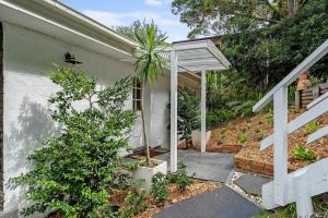 a house with a palm tree in front of it at North Avoca Coastal Escape in North Avoca