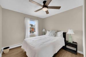 a bedroom with a white bed and a ceiling fan at Between Tides 2BR Walk to Beach Unit C in Seaside Park