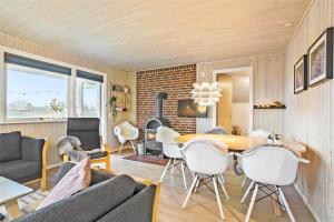 a living room with a table and chairs and a fireplace at SJ232-Hejls-Humlevaenget-8 in Hejls