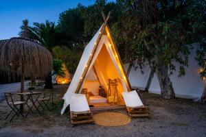 a teepee tent with chairs and a table and a table at Kampaoh Paloma in Tarifa
