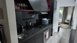 a kitchen with a counter with a sink and a microwave at Lora Gardens in Chartwell +13 photos