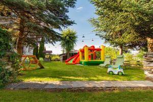 a yard with a playground with play equipment in the grass at Дедовата Къща in Dedovo +54 photos