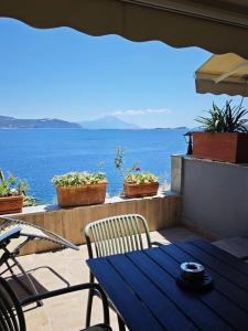 eine Terrasse mit Tisch und Stühlen und dem Meer in der Unterkunft Drenia Studios in Amolianí