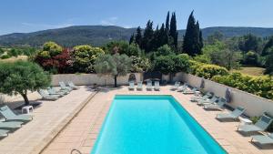 a swimming pool with chaise lounge chairs and a resort at Château de Floure - SPA et piscine extérieure chauffée in Carcassonne
