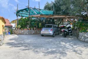 a car and a motorcycle parked in a parking lot at Casa Vacanze Chery in Sorrento +29 photos
