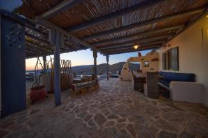 a patio with a blue couch and a table at EMERALD Villa in Kithnos