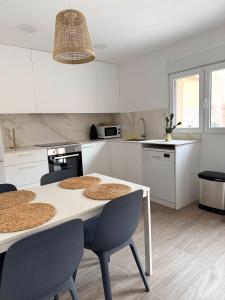 a white kitchen with a table and chairs in it at Casa Silvestre in Puigmoreno
