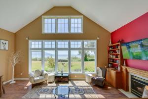 a living room with a large window and a flat screen tv at Waterfront Bellingham Bliss: Steps to Beach! in Bellingham