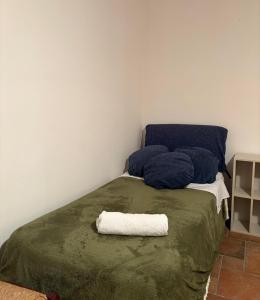 a bed with blue pillows and a towel on it at Troina rooms in Troina