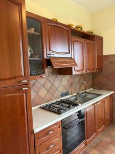 a kitchen with wooden cabinets and a stove top oven at Troina rooms in Troina