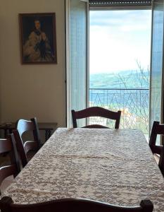 a dining room with a table and a large window at Troina rooms in Troina