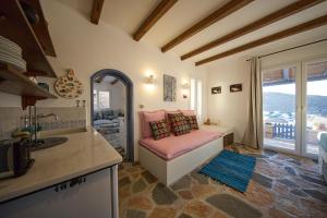 a kitchen with a couch in a room with a window at EMERALD Villa in Kithnos