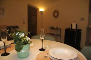a table with two wine glasses and a vase of flowers at Il nido di Acqui in Acqui Terme +3 photos