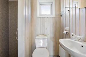 a bathroom with a toilet and a sink and a window at LN1789-Hjorring-Indemarken-44 in Hjørring +13 photos