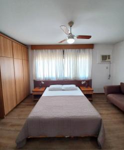 a bedroom with a large bed and a couch at JK Studio centro, você merece o melhor! in Novo Hamburgo