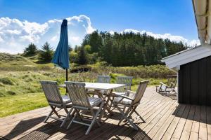 a table and chairs with an umbrella on a deck at LN1789-Hjorring-Indemarken-44 in Hjørring