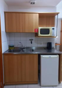 a kitchen with a sink and a microwave at JK Studio centro, você merece o melhor! in Novo Hamburgo