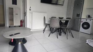 a living room with a table and chairs and a kitchen at Paralia Sea View Suites in Paralia Katerinis