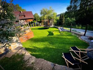 a lawn with chairs and a gazebo at Chata u Bożeny in Muszyna