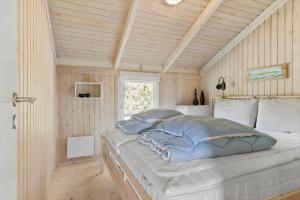 a bedroom with a bed in a room with wooden walls at LN1959-Hirtshals-Tangen-3 in Hirtshals