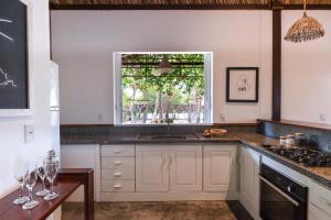 a kitchen with white cabinets and a window at Casa Shaka in Atins