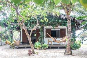 a house with a hammock in the middle of trees at Casa Shaka in Atins