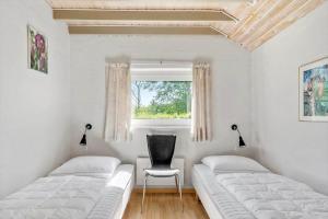 a bedroom with two beds and a chair and a window at SJ296-Hejls-Ae-Skovbryn-37 in Hejls