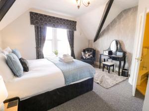 a bedroom with a large bed and a desk at The Causeway in Llandudno