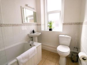 a white bathroom with a toilet and a sink at The Causeway in Llandudno +84 photos