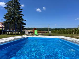 a swimming pool with blue water in a yard at Mattys ranč Všeteč in Všemyslice