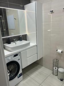 a bathroom with a washing machine and a sink at Apartio Bella in Vysoké Tatry