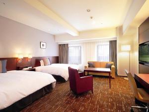 a hotel room with two beds and a television at Akita Castle Hotel in Akita +70 photos