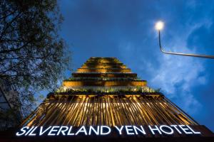 a large building with a clock on it's side at Silverland Yen Hotel in Ho Chi Minh City