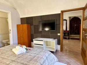 a bedroom with a bed and a flat screen tv at Casa Paulina in Scanno