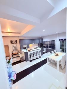 a large living room with a kitchen and a table at Swansea Villa 3 BR in Ban Huai Yai
